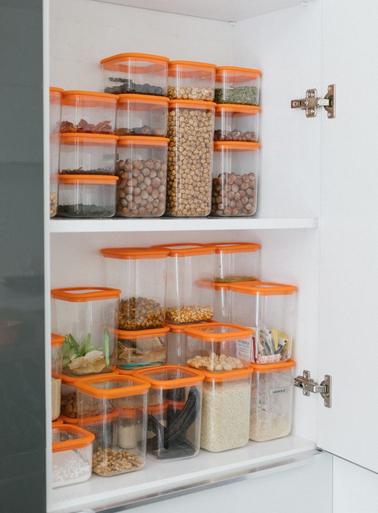 "Stacked airtight plastic pantry containers with orange lids".
