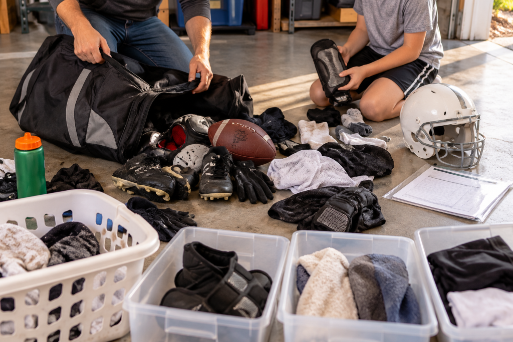 A parent and child emptying a sports bag at the end of the season